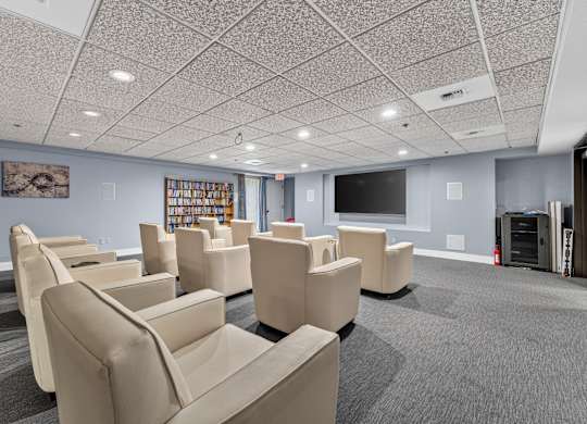 Movie room with large comfy beige chairs, grey carpet