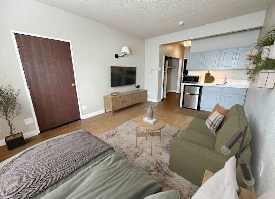 A living room with a couch, a chair, a coffee table, and a television.