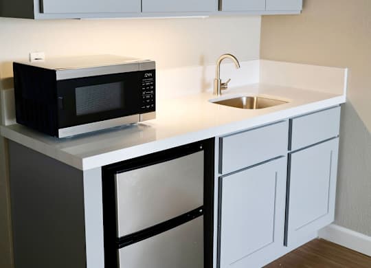 A black microwave oven is on a white countertop.
