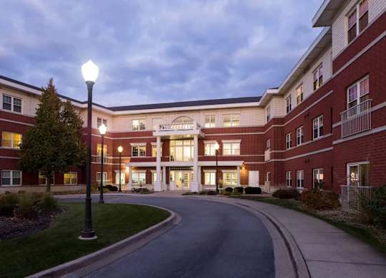A streetlight stands on a sidewalk in front of a red brick building.