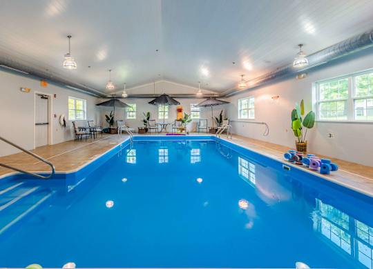 Indoor swimming pool with seating area at Schuyler Commons Apartments, Utica, New York