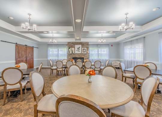 Community dining room with fireplace and tables at Schuyler Commons Apartments, Utica, 13502