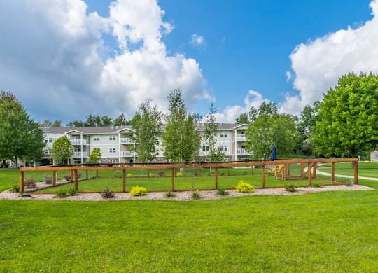 Fenced dog park area with landscaping at Schuyler Commons Apartments, Utica, New York