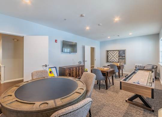 Game room with poker table and shuffleboard at Glenmont Abbey Village, 55+ Apartments, New Jersey, 12077