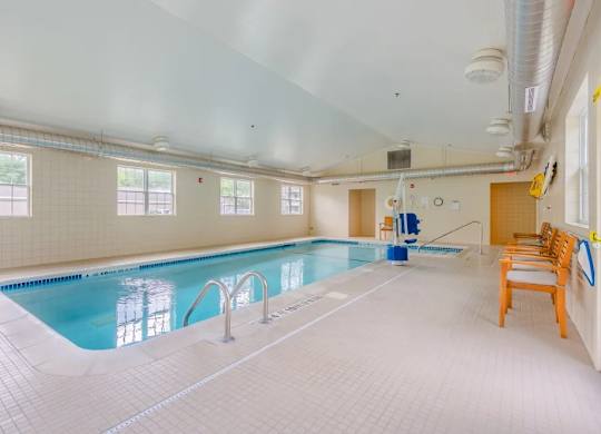Indoor swimming pool with seating area at Glenmont Abbey Village, 55+ Apartments, Glenmont, NJ 12077