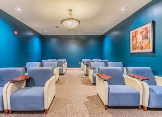 Movie theater with blue walls and reclining chairs at Glenmont Abbey Village, 55+ Apartments, New Jersey