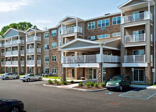 Multi story apartment building with stone accents at Glenmont Abbey Village, 55+ Apartments, New Jersey