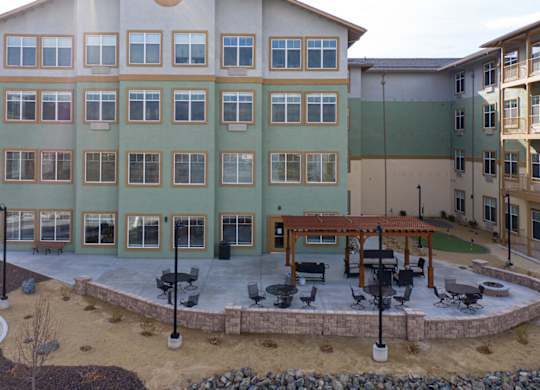 Four story apartment building with outdoor patio area at Mountain Lakes Estates Apartments, Reno