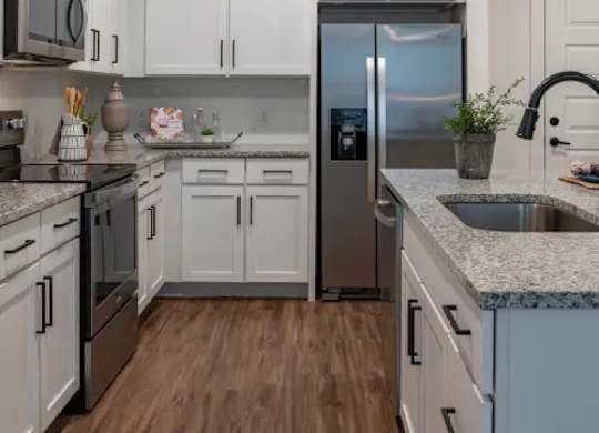 A kitchen with white cabinets and a stainless steel refrigerator. at Atwater at Nocatee Apartments, Toledo, Florida