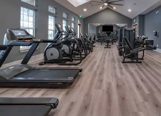 A gym with treadmills, elliptical machines, and a ceiling fan. at Atwater at Nocatee Apartments, Toledo, 32081
