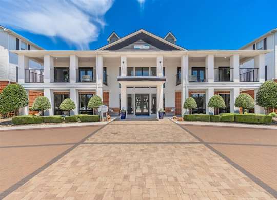 A large, modern building with a central entrance and a symmetrical facade. at The Spring at Silverton Apartments, Texas