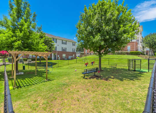 A park with a playground and a building in the background. at The Spring at Silverton Apartments, Fort Worth, TX