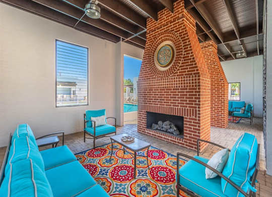 A living room with a fireplace and blue couches. at The Spring at Silverton Apartments, Fort Worth, TX, 76133