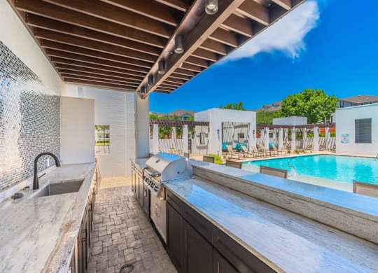 A kitchen with a pool in the background. at The Spring at Silverton Apartments, Fort Worth, TX