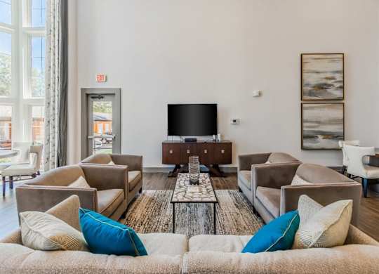 A living room with a large couch and a flat screen TV. at The Spring at Silverton Apartments, Texas
