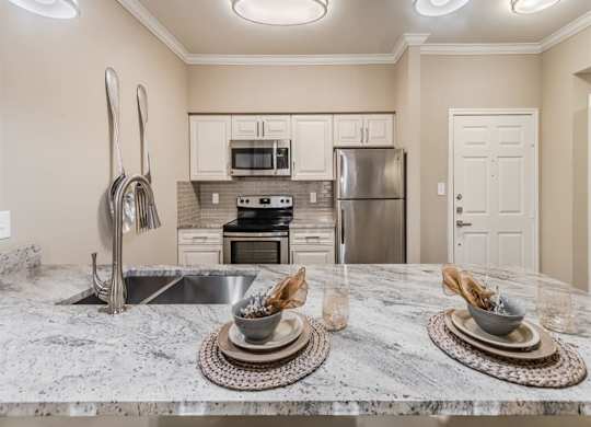 A kitchen with a marble countertop and stainless steel appliances. at The Spring at Silverton Apartments, Fort Worth, TX, 76133