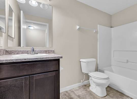 A bathroom with a toilet, sink, and bathtub.