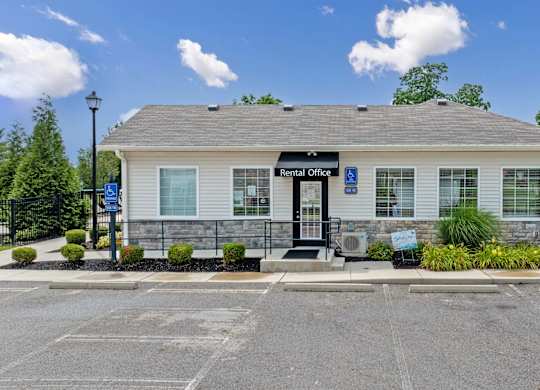 A rental office building with a parking lot in front.