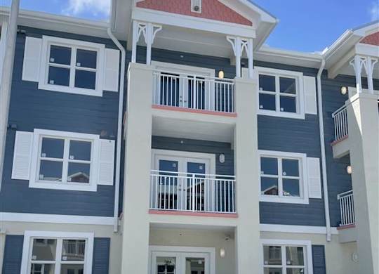 A multi-story building with a red roof and white railings.