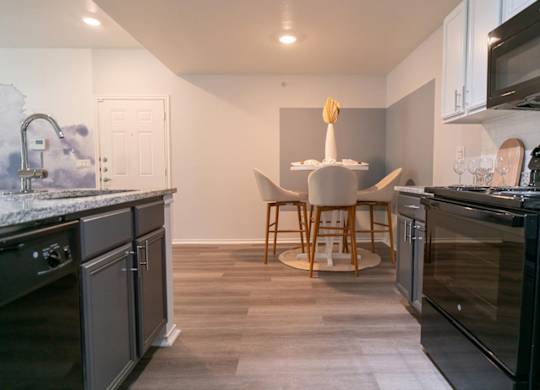 A kitchen with a table and chairs in the middle.