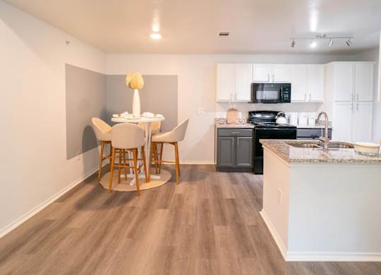 A kitchen with a table and chairs in the middle of the room.