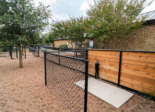 A playground with a black fence and a wooden wall.