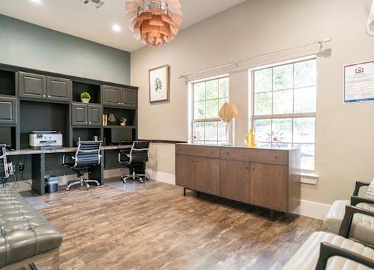 A room with a desk, chairs, and a couch.