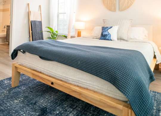 A bedroom with a bed, a ceiling fan, and a rug.