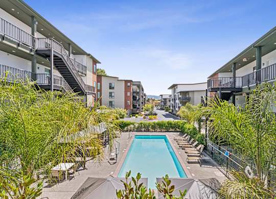 A pool surrounded by buildings and trees.
