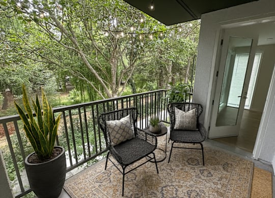 A balcony with a chair and a potted plant.