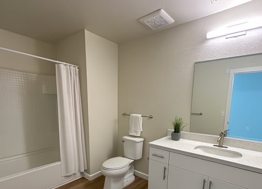A white toilet sits in a bathroom next to a sink.