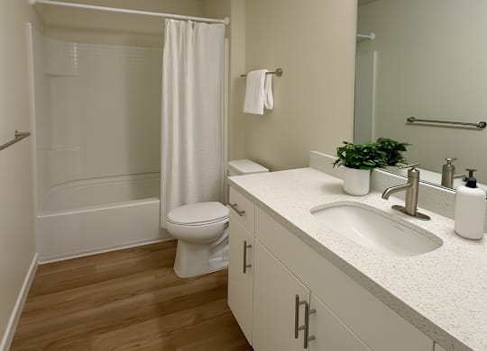 A white bathroom with a toilet, sink, and shower.