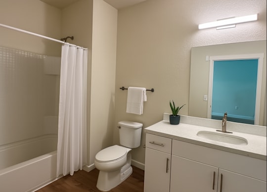 A white toilet sits in a bathroom next to a white sink.