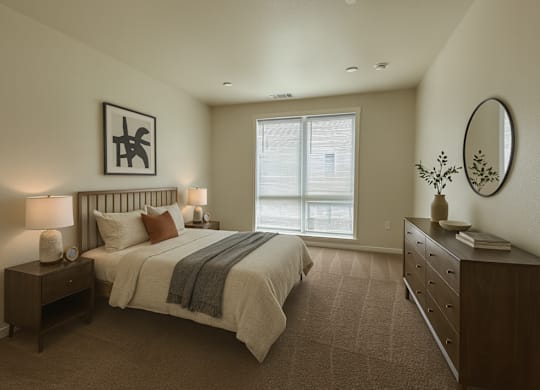 A bedroom with a large bed, a nightstand with a lamp, and a dresser with a mirror.
