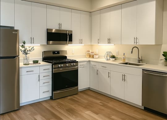 A modern kitchen with white cabinets and stainless steel appliances.