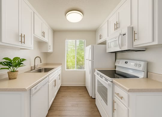 A kitchen with white cabinets and appliances.