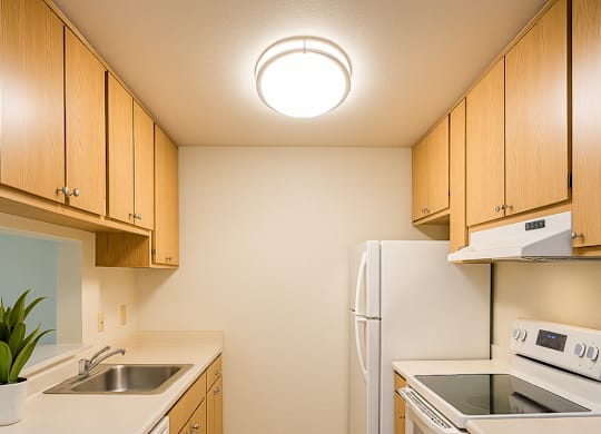 A kitchen with wooden cabinets and white appliances.