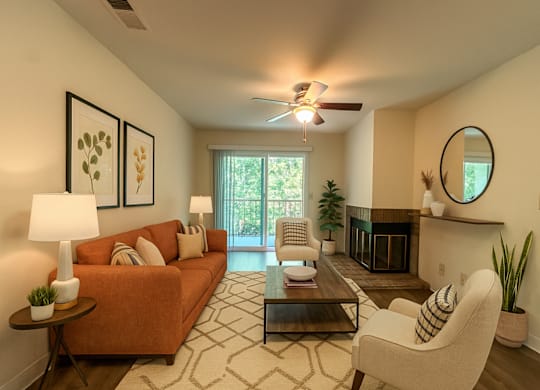 A living room with a couch, chair, and fireplace.