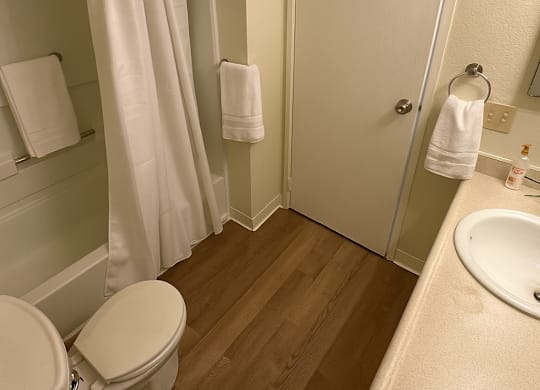 A white toilet sits next to a white sink in a small bathroom.