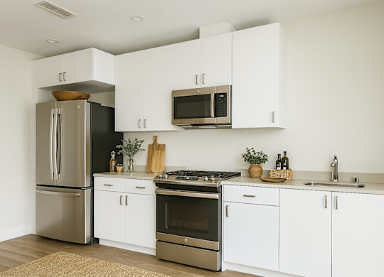A modern kitchen with white cabinets and stainless steel appliances.at Edgeway Plaza, California, 94928