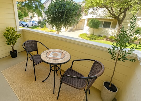 A patio with a table and chairs overlooking a street.