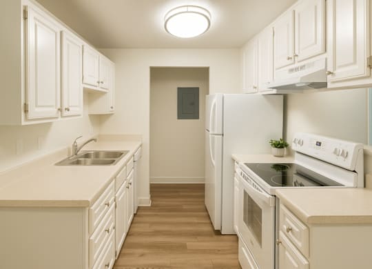 A kitchen with white appliances and cabinets.