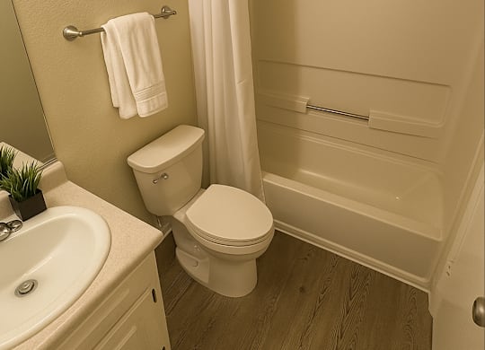 A white toilet sits next to a white sink in a bathroom.