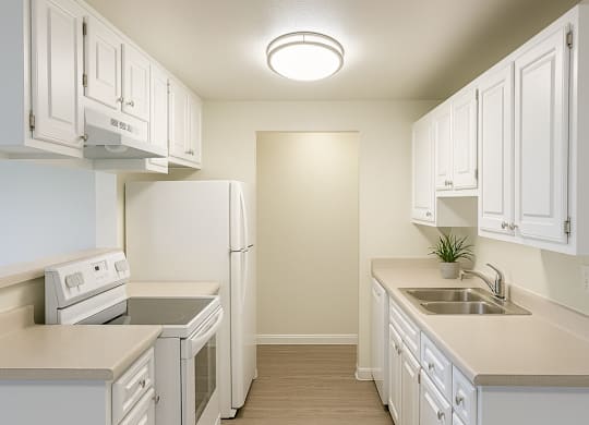 A kitchen with white cabinets and appliances.