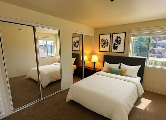 A bedroom with a large bed and a mirror on the wall.