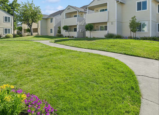 A residential area with apartment buildings and a well-maintained lawn.