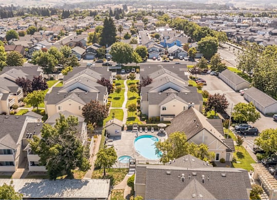 A bird's eye view of a residential area with houses and a swimming pool.