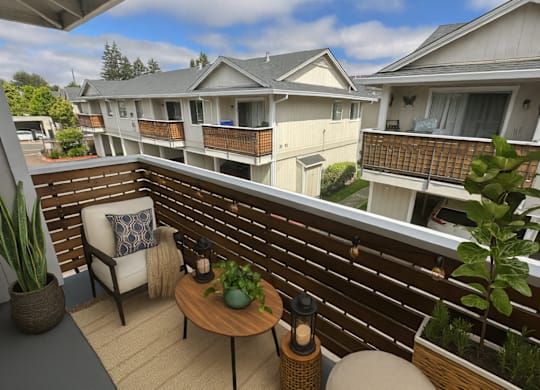 A balcony with a chair, table, and potted plants.
