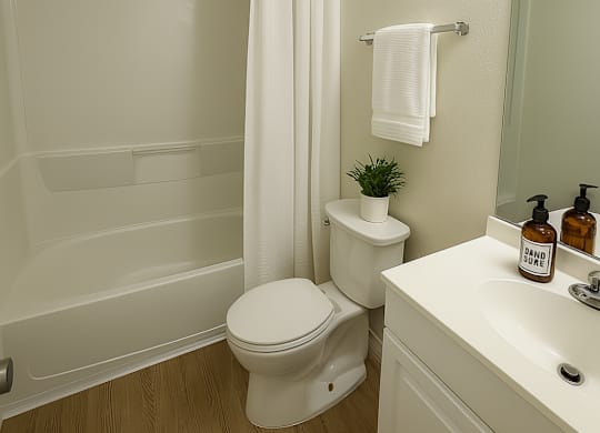 A white toilet sits next to a white sink in a small bathroom.