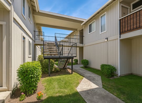 A small balcony with a metal railing is on the second floor of a building.